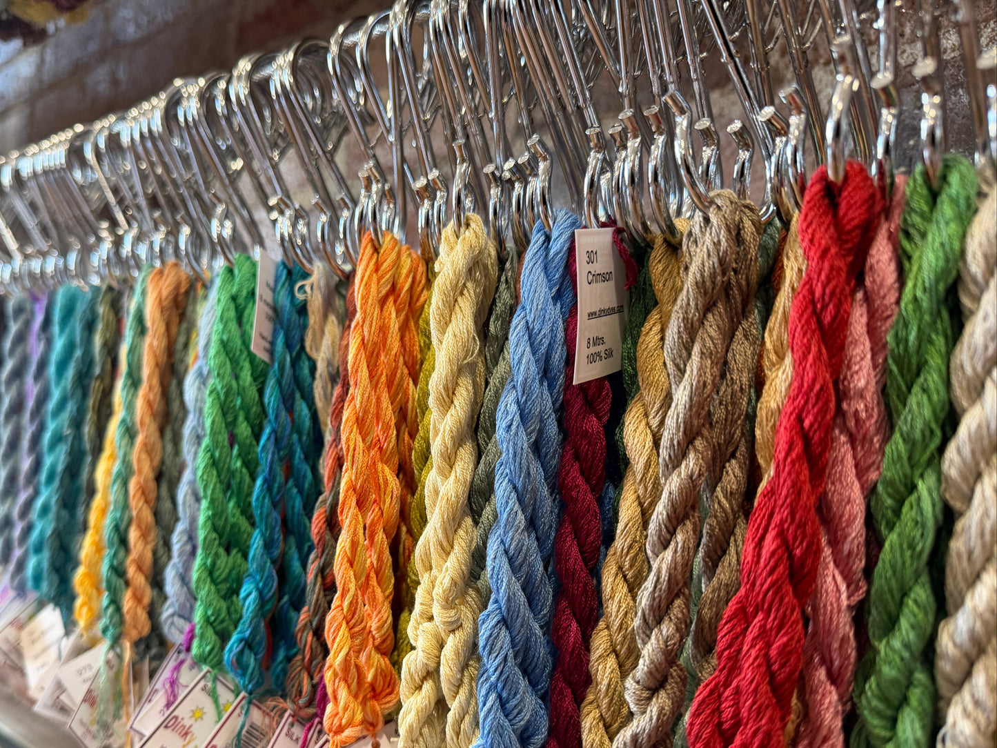 Colorful yarn on hangers with price tags in a store setting
