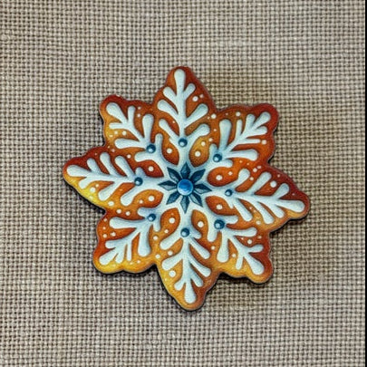 Decorative snowflake cookie on a textured fabric background