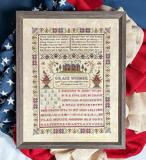 Framed cross stitch pattern on a decorative wreath with American flag colors