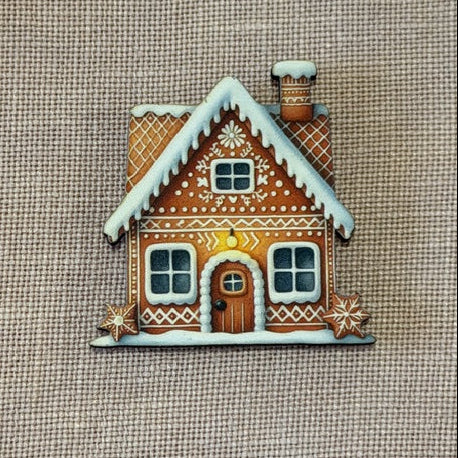 Decorative gingerbread house cookie on a textured fabric background