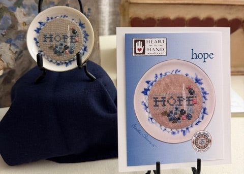 Cross-stitch kit with 'hope' design on a table