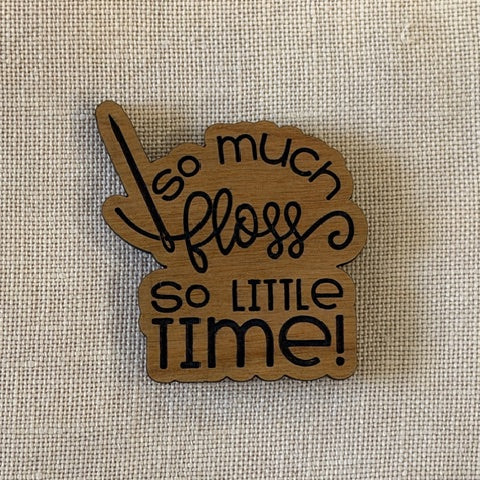wooden needleminder that says "so much floss so little time"